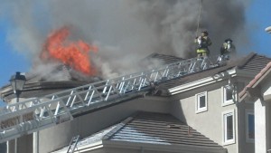 Firefighters access the roof from Truck 1 at a working fire on Autumn Oak Circle in Concord on Friday, March 29, 2013